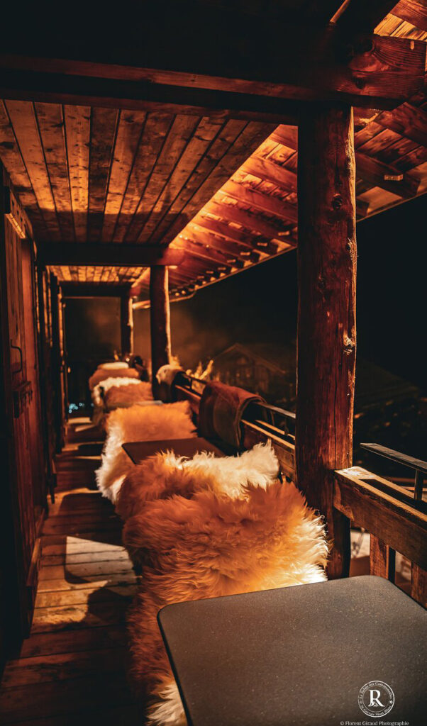 Balcon suspendu au dessus de la terrasse du restaurant offrant une vue panoramique sur les montagnes enneigées.